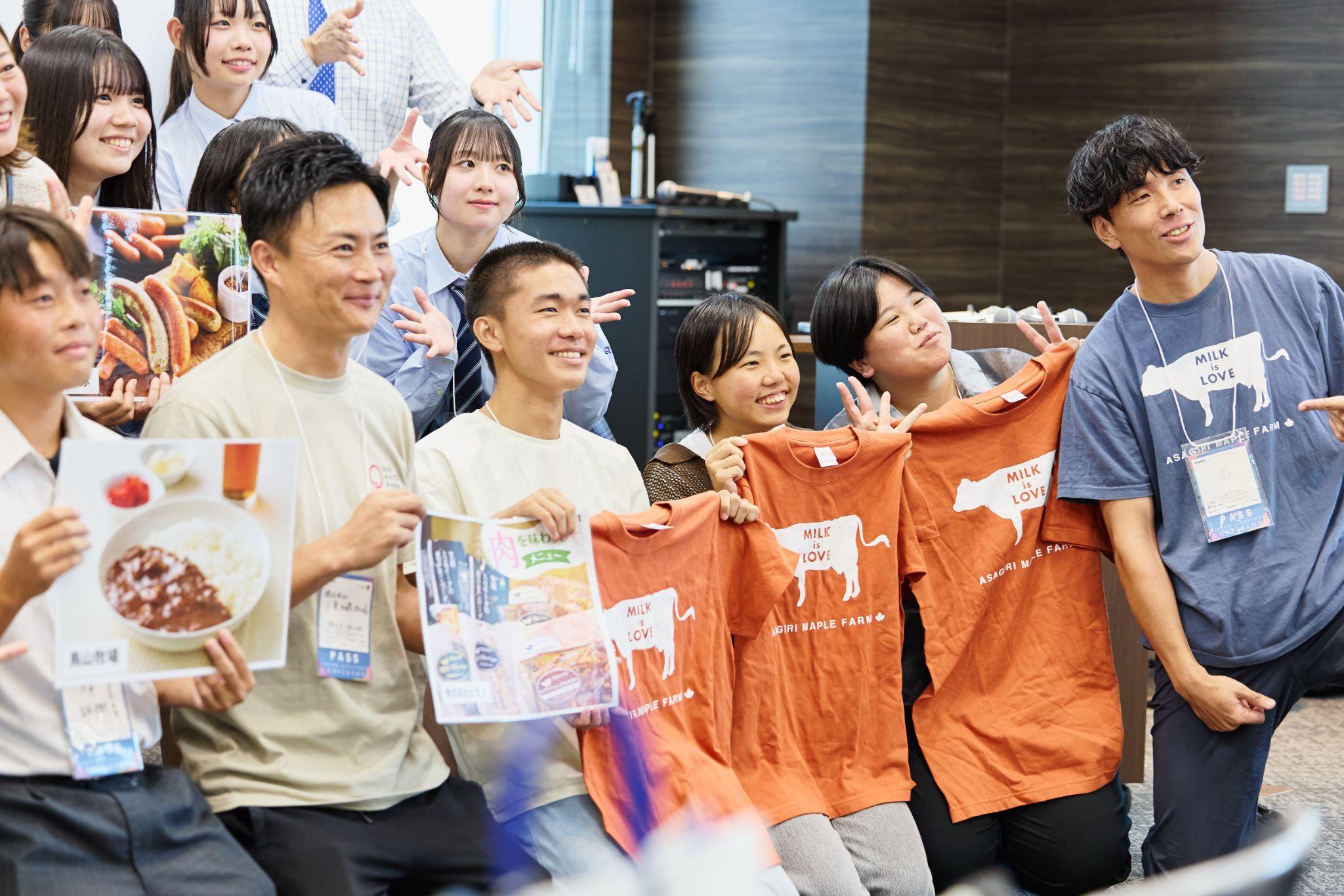 学生プレゼン大会で朝霧メイプルファームの“牛乳は愛”Tシャツが贈られた高校生たちと丸山さん。